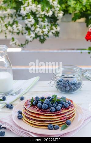 Una delizia prima colazione con frutta fresca su party in giardino, al di fuori di fiori dietro e erbe aromatiche fresche sulla parte superiore Foto Stock