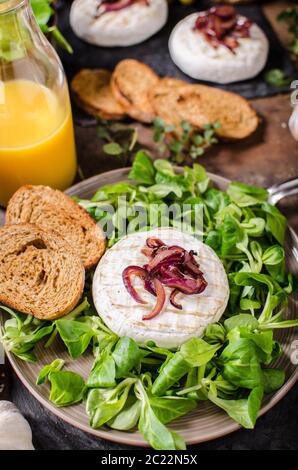 Grigliata di formaggio Camembert con insalata, panini e pane dolce di cipolla rossa Foto Stock