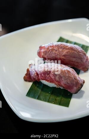 Wagyu carni bovine il sushi giapponese gastronomo che cucina, sulla piastra bianca Foto Stock