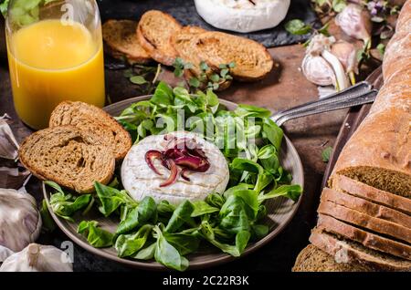 Grigliata di formaggio Camembert con insalata, panini e pane dolce di cipolla rossa Foto Stock