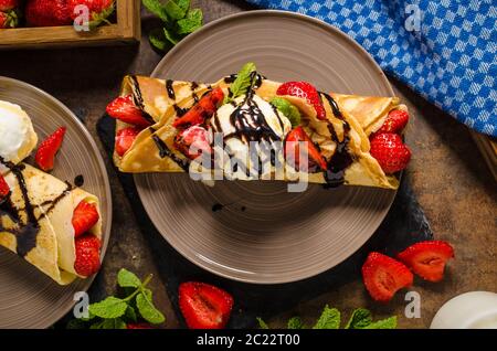 Crepes con gelato, Topping Caramel e fragole. Deliziosa casa creame caramello Foto Stock