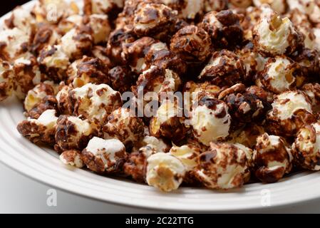 Primo piano di popcorn al cioccolato su piatto bianco Foto Stock