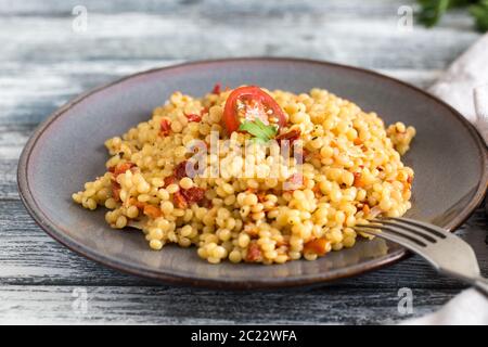 Ptitim o Birdy, Israeliano paste alimentari Cuscus con pomodori e le erbe/ Foto Stock