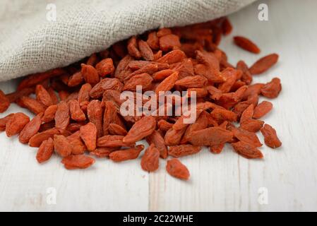 Primo piano di bacche di goji essiccate su tavolo di legno Foto Stock