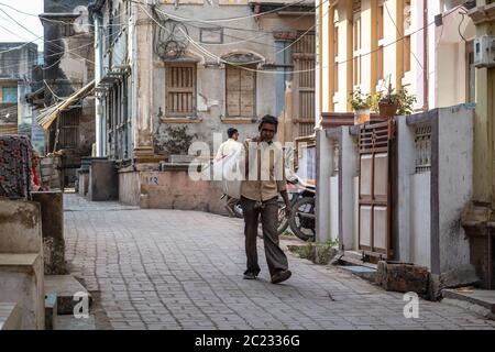 Somnath, Gujarat, India - Dicembre 2018: Un uomo indiano che porta un sacco di beni sulle strade del patrimonio della città vecchia. Foto Stock