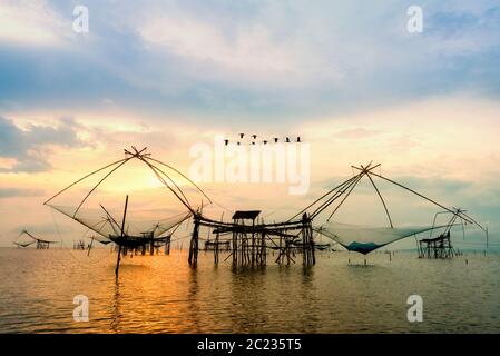 Bellissima natura luce dorata del mattino cielo ad alba con stormo di uccelli sorvolano il nativo di attrezzo di pesca, stile di vita rurale a Foto Stock