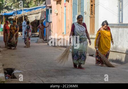 Somnath, Gujarat, India - Dicembre 2018: Due donne indiane che indossano sari che spazzano le strade della città con i bastoncini di criciomo. Foto Stock