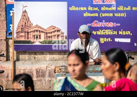Somnath, Gujarat, India - Dicembre 2018: Un uomo indiano che indossa un cappello che lavora al banco del tempio nella città Santa. Foto Stock