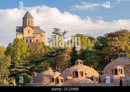 Cupole di bagni sulfurei e Metekhi Chiesa, a Tbilisi, Georgia Foto Stock