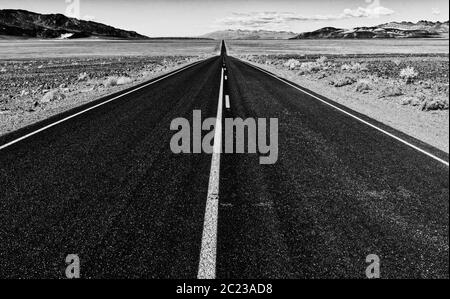 Vista di un interminabile dritta strada che corre attraverso il deserto NEGLI STATI UNITI Foto Stock