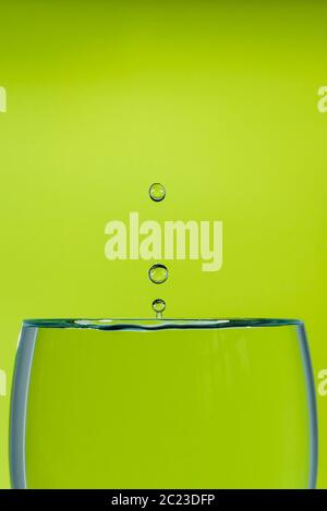 Immagine di uno studio interno di una caduta d'acqua ad alta velocità su sfondo verde Foto Stock