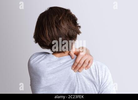 Dolore alla schiena e alle spalle causato dal lavoro al computer. L'uomo preme la mano per irritare il punto Foto Stock