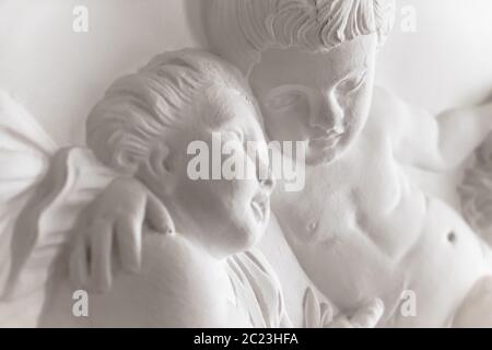 Dettagli di architettura di intonaco bianco statua con putti (putti). Ideale per i concetti e gli sfondi. Foto Stock