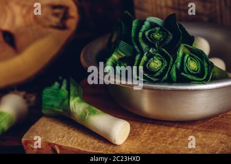 Fresco verde porro in grigio coppa sopra una superficie di legno Foto Stock