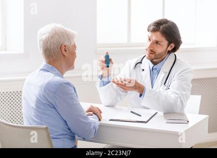Medico che spiega il programma delle pillole al paziente anziano Foto Stock