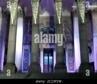 L'ingresso e le colonne del Municipio di Leeds nello yorkshire occidentale sono illuminate di notte Foto Stock