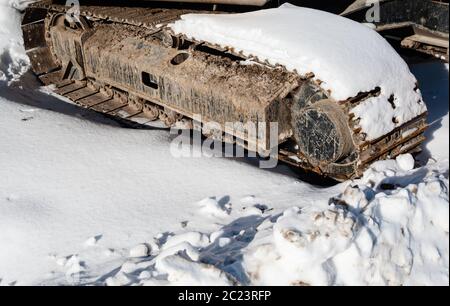 Parte di industriali pesanti tracce continue coperto di neve sulla giornata di sole. Foto Stock