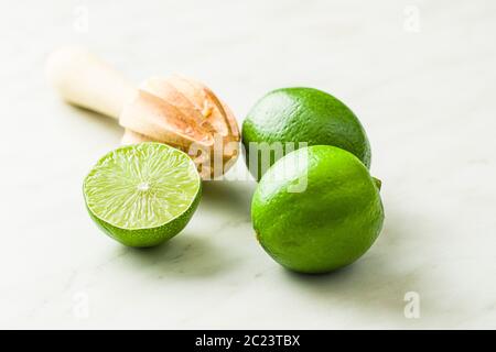 Legno spremitore di agrumi e verde lime sul tavolo da cucina. Foto Stock