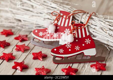 Decorativo Natale ancora vita nordica stile in rosso e bianco con carino ornamento in forma di pattinaggio su ghiaccio e stelle rosse Foto Stock