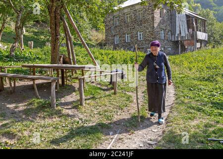 Signora georgiana nel villaggio a piedi, a Ushguli, Georgia Foto Stock