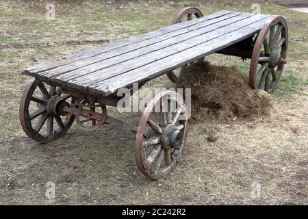 Carrello vintage con ruote in legno nel cortile Foto Stock