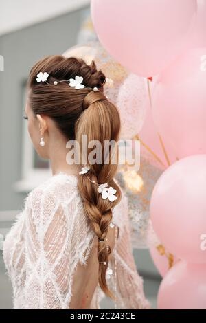 Slim stordimento brunette con fiori nei capelli e abito bianco. Foto Stock