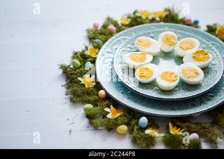 Pasqua messa in tavola con i fiori e le uova. Piatti decorativi con uova sode Foto Stock