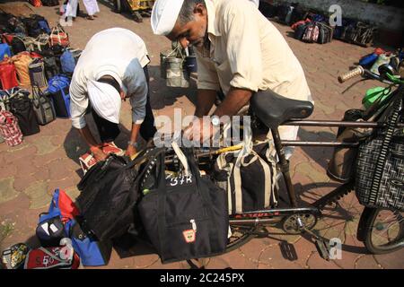 Consegna Dabbawala di pranzi con cibo caldo alla stazione ferroviaria Churchgate di Mumbai (Bombay), India. Un servizio di consegna di cibo tradizionale molto efficiente Foto Stock