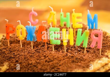 Torta di compleanno felice con candele in forma di lettere russe Foto Stock