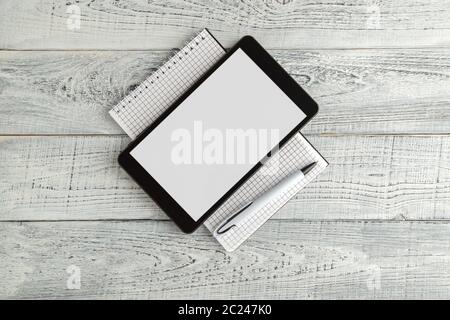 Nero tavoletta elettronica e carta del notebook su vintage shabby bianco sullo sfondo di legno. La vista dall'alto. laici piatta Foto Stock