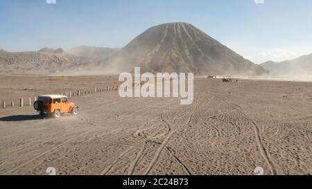 Vista cinematografica del drone aereo del tour in jeep crociera sul bellissimo vulcano del Monte bromo con deserto a Giava Est, Indonesia Foto Stock