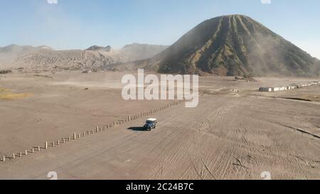 Vista cinematografica del drone aereo del tour in jeep crociera sul bellissimo vulcano del Monte bromo con deserto a Giava Est, Indonesia Foto Stock