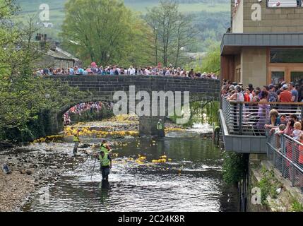 persone e volontari che guardano l'annuale corsa di anatre di beneficenza del lunedì di pasqua nel ponte di hebden Foto Stock