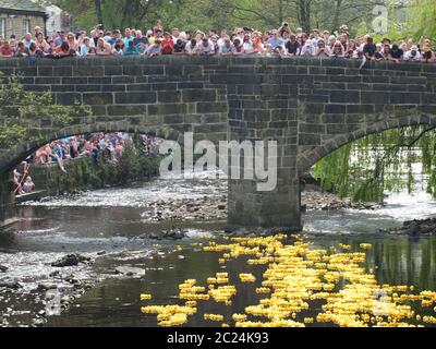 persone e volontari che guardano l'annuale corsa di anatre di beneficenza del lunedì di pasqua nel ponte di hebden Foto Stock