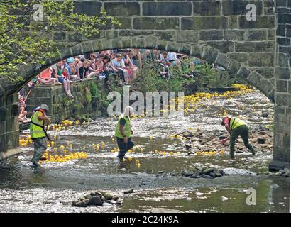 persone e volontari che guardano l'annuale corsa di anatre di beneficenza del lunedì di pasqua nel ponte di hebden Foto Stock