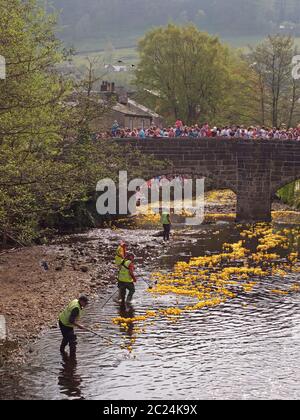 persone e volontari che guardano l'annuale corsa di anatre di beneficenza del lunedì di pasqua nel ponte di hebden Foto Stock