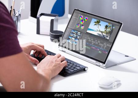 Giovane Maschio Editor Editing video sul computer in ufficio Foto Stock