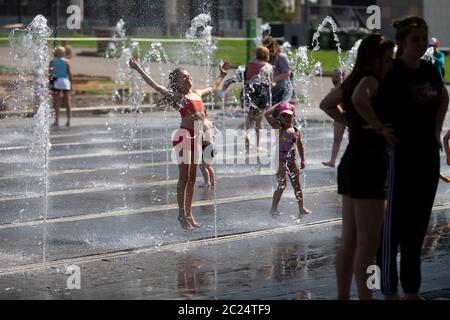 Mosca, Russia. 16 Giugno 2020. I bambini giocano in una fontana al Museon Park di Mosca, Russia, il 16 giugno 2020. La Russia ha aggiunto 8,248 casi COVID-19 nelle ultime 24 ore, portando il suo totale a 545,458, il centro di risposta del paese coronavirus ha detto in una dichiarazione Martedì. La città di Mosca ha iniziato a vivere martedì, entrando in una nuova fase. Credit: Alessandro Zemlianichenko Jr/Xinhua/Alamy Live News Foto Stock