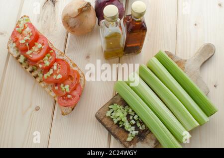 Baguette alla griglia con pomodori grigliati, olio di oliva e di sedano tagliato Foto Stock