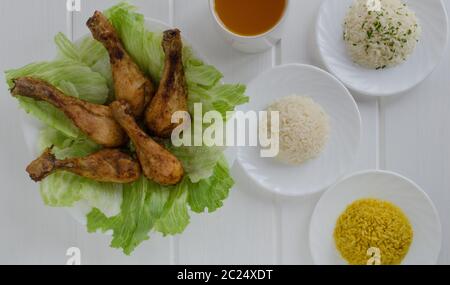 Grigliata di cosce di pollo con riso tre su legno bianco Foto Stock