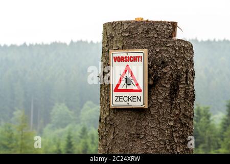 Cartello segnaletico per le zecche, nella foresta di Arnsberg, vicino Hirschberg, Sauerland, NRW, Germania Foto Stock