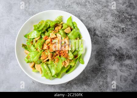 Mescolare i piselli di neve fritto con salsiccia di maiale alla griglia vietnamita Foto Stock