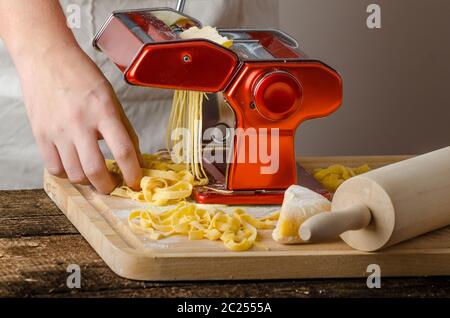 Lo Chef produzione pasta - La pasta italiana La cucina del macinino, wood board, mattarello, tutti realizzati da farina di semola Foto Stock