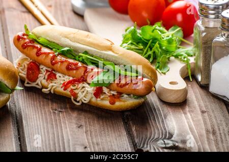 Variazione su red hot dogs, cipolla pomodoro, rucola e peperoncino piccante con spaghetti cinesi Foto Stock