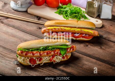 Variazione su red hot dogs, cipolla pomodoro, rucola e peperoncino piccante con spaghetti cinesi Foto Stock