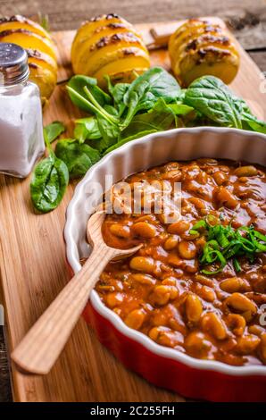 Cowboy piccante fagioli con peperoncino jalapeno, lo scalogno e la pancetta, Hassleback Potatoe con erbe aromatiche Foto Stock