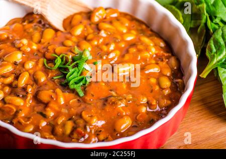 Cowboy piccante fagioli con peperoncino jalapeno, lo scalogno e la pancetta, Hassleback Potatoe con erbe aromatiche Foto Stock