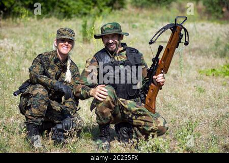 I soldati femminili e maschili in uniformi militari sono all'aperto in natura. Foto Stock