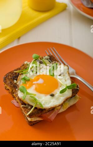 Cotta toast alla francese - Croque Madame, succo di arancia, girasole microgreens sulla parte superiore Foto Stock