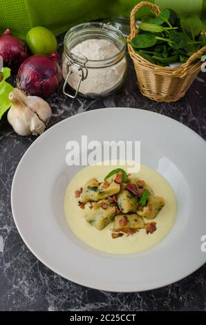 Gnocchetti di spinaci con salsa di Parmigiano e rabboccato con pancetta, pulire serve, ingredienti in background Foto Stock